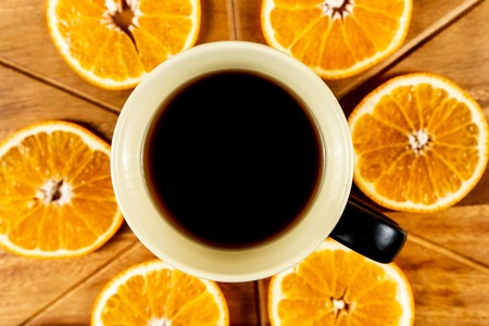 Orange Slices On Wooden Cutting Board and a mug of coffe.の写真素材