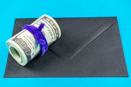 Prop Money Dollars and black envelope.Light blue backgroundの写真素材