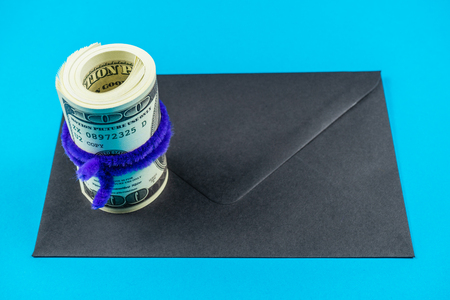 Prop Money Dollars and black envelope.Light blue backgroundの写真素材