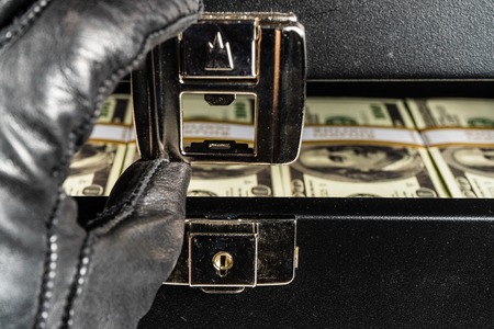 Black case full of dollar bills close up.Money bricks in case.