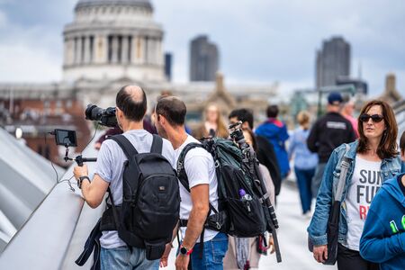 London, UK, July, 2019. Two videographers shooting video near St Pauls Cathedral and Millennium Bridge over the River Thames in Londonのeditorial素材
