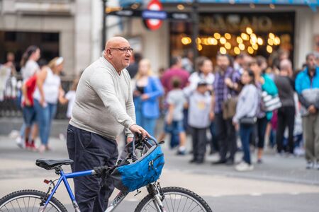 London, UK, July 28, 2019. Male cyclist standing with his bike at Piccadilly Circus.のeditorial素材