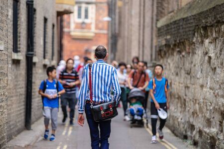 Stylish men walking down the street. Rear view of Stylish men walking at Cambridgeの写真素材