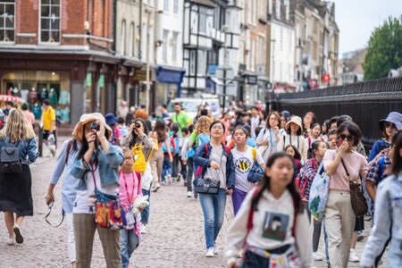 Cambridge, UK, August 1, 2019. Turists walking down and taking pictures at the street of Cambridge...