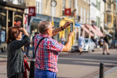 Cambridge, UK, August 1, 2019. Turists walking down and taking pictures at the street of Cambridge on a busy sunny day in front of Kings Collegeのeditorial素材