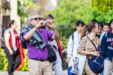Cambridge, UK, August 1, 2019. Turists walking down and taking pictures at the street of Cambridge on a busy sunny day in front of Kings Collegeのeditorial素材