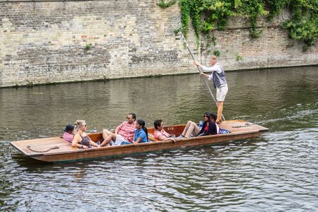 Cambridge, UK, August 1, 2019. The punter pushes a pole against the river bed and this gives the punt a way to moveのeditorial素材