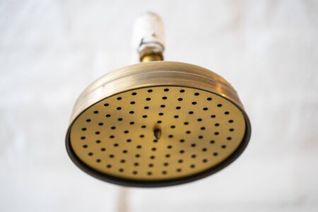 Closeup of a vintage old brass shower head in the bath roomの写真素材