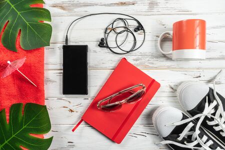 Fashion Weekly Planner, mug, towel, snickers, modern headphones and mobile phone on white rustic wood table.の写真素材