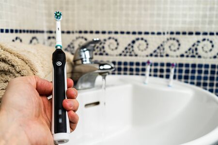 Electric Rechargeable Toothbrush with a Black Handle and five Toothbrush Heads.Light blue backgroundの写真素材