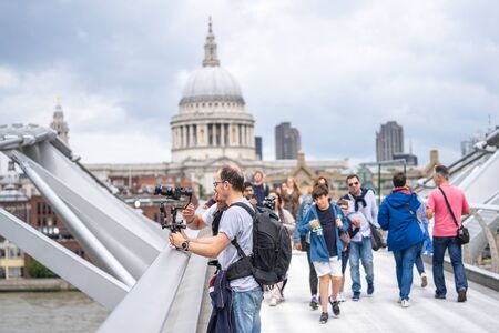 London, UK, July, 2019. Two videographers shooting video near St Pauls Cathedral and Millennium Bridge over the River Thames in Londonのeditorial素材