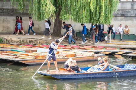Cambridge, UK, August 1, 2019. The punter pushes a pole against the river bed and this gives the punt a way to moveのeditorial素材