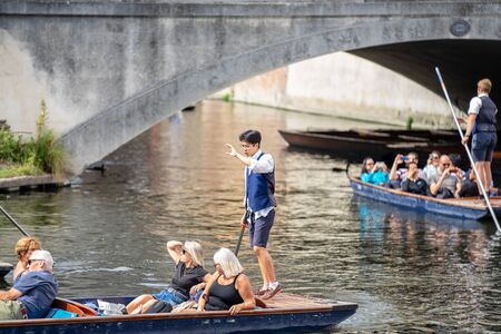 Cambridge, UK, August 1, 2019. The punter pushes a pole against the river bed and this gives the punt a way to moveのeditorial素材