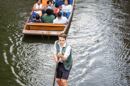 Cambridge, UK, August 1, 2019. The punter pushes a pole against the river bed and this gives the punt a way to moveのeditorial素材