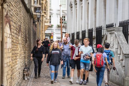 Cambridge, UK, August 1, 2019. Turists walking down and taking pictures at the street of Cambridge...