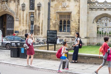 Cambridge, UK, August 1, 2019. Turists walking down and taking pictures at the street of Cambridge on a busy sunny day in front of Kings Collegeのeditorial素材