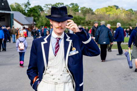 OLD WARDEN, BEDFORDSHIRE, UK, OCTOBER 6, 2019.1914 Motorsport enthusiasts wearing period dress cheer...