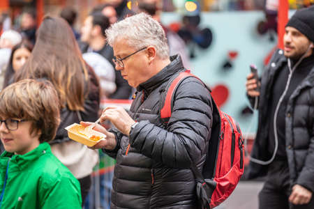 A man eats street Chinese food in China Town London. London, January 26, 2020