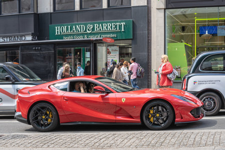 A young couple sitting in Ferrari on a narrow street in London. UK, London, May 29, 2021のeditorial素材
