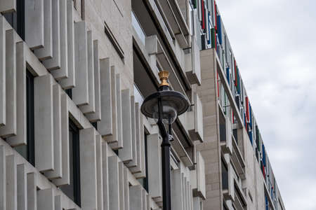 A fragment of a modern building with a street lamp in front of itの写真素材