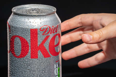 Hand stretching to a cold water drops covered can of diet Coca-Cola.London, Britain, June 19, 2021のeditorial素材