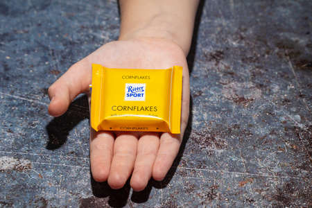 Ritter sport CORNFLAKE Milk Chocolate lying in the palm of a little girl. Bedford,UK, August 25,...