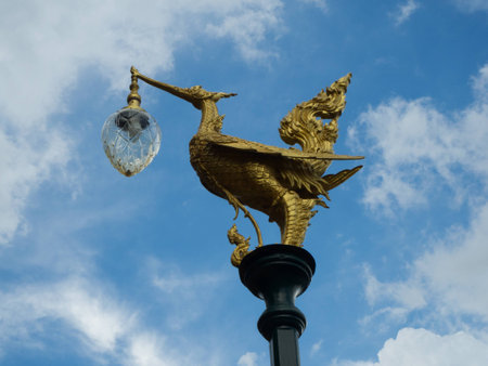 sculpture of golden swarn light pole and blue skyの写真素材