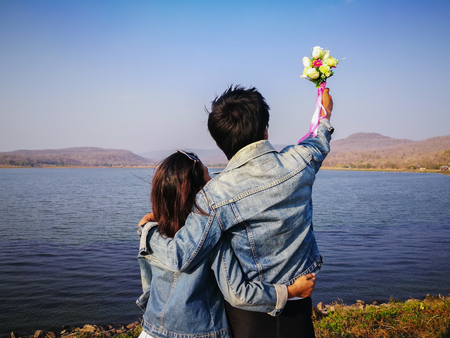 back view couples in jeans jecket standing happy cliffside looking sea view, Kalasin Thailandの写真素材