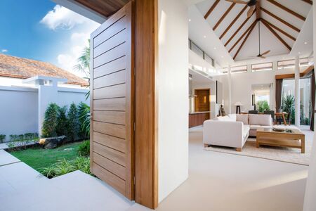Luxury interior design in livingroom of pool villas. Airy and bright space with high raised ceiling and wooden dining tableの写真素材