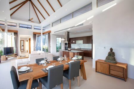 Luxury interior design in livingroom of pool villas. Airy and bright space with high raised ceiling and wooden dining tableの写真素材