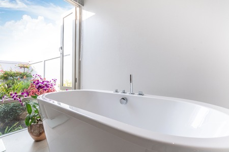 Luxury bathroom features bathtub with flowerの写真素材