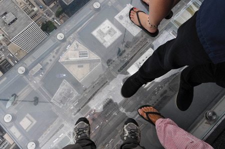 Feet on the glass balcony of the Willis Tower, Chicagoの写真素材