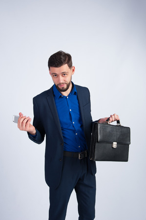 Successful businessman with phone and briefcaseの写真素材