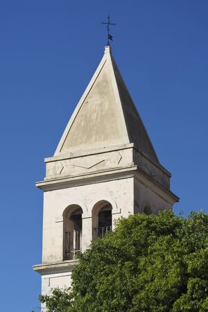 church tower above the tree, with the blue sky in the backgroundの写真素材