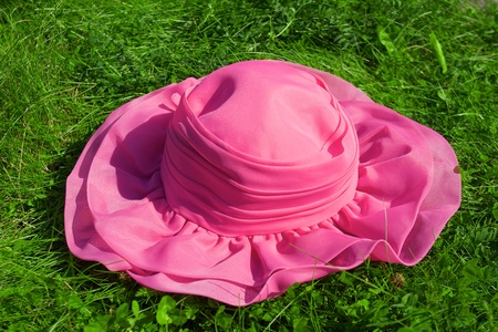 Pink hat on the green grass backgroundの写真素材