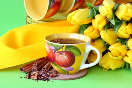 Tea cups and yellow tulips on green backgroundの写真素材