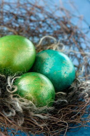 Easter colorful eggs in nest on blue backgroundの写真素材