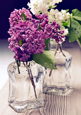 Bouquet of lilac in a vase on wooden tableの写真素材