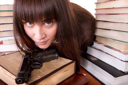 Girl with heap book and weapon. Isolated.の写真素材