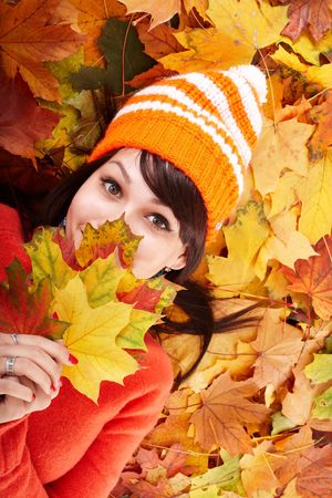Girl in autumn orange hat on leaf group. Outdoor.の写真素材