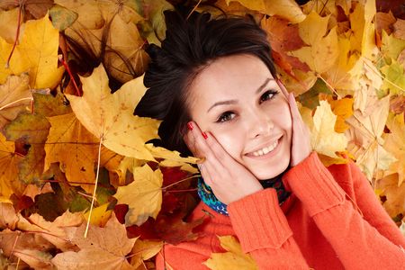 Girl in autumn orange hat on leaf group. Outdoor.の写真素材
