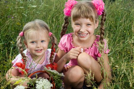 Two little girl in green grass. Nature.の写真素材