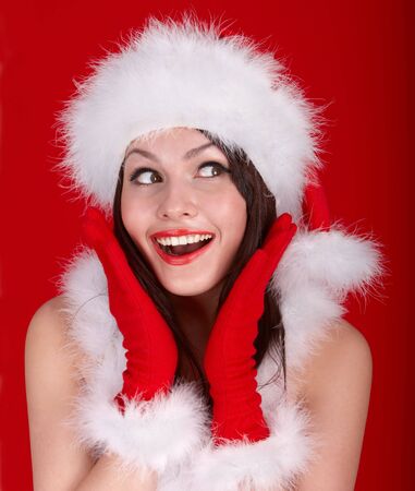Christmas girl in red santa hat. Red background.の写真素材