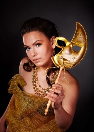 Beautiful young woman with gold mask on grey background.の写真素材