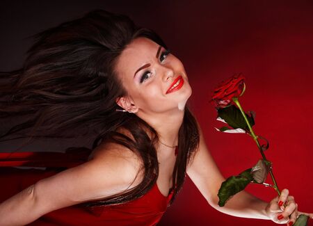 Girl with red flower rose  running. Valentines day.の写真素材