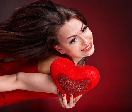 Girl with heart on red background flying. Valentines day.の写真素材