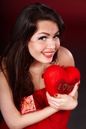 Girl with  heart  and gift box on red  background.   Valentines day.の写真素材
