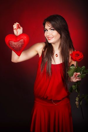 Girl with  heart and flower rose on red  background.  Valentines day.の写真素材
