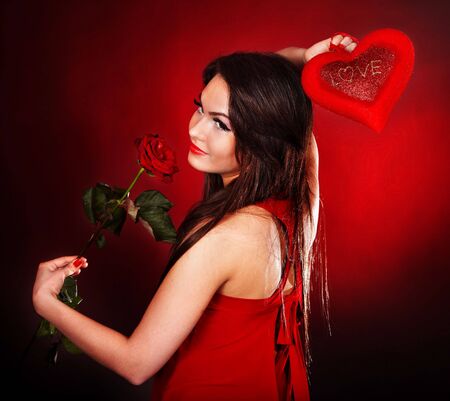 Girl with  heart and flower rose on red  background.  Valentines day.の写真素材