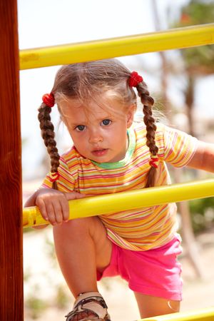Child girl on ladder in playground.Outdoor park.の写真素材